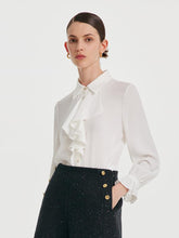 A lady wears a white shirt and black shorts.
